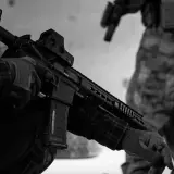 Maintenant, peut-on avoir un airsoft dans sa voiture ? Un joueur en tenue tactique manipule son réplique d'airsoft.
