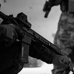 Maintenant, peut-on avoir un airsoft dans sa voiture ? Un joueur en tenue tactique manipule son réplique d'airsoft.