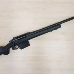 Fusil noir Remington 700 Police, prêt pour l'action sur fond de bois clair.