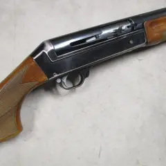 Le fusil de chasse Benelli 121, avec sa crosse en bois et son mécanisme apparent, prêt pour l'action.