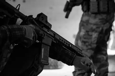 Maintenant, peut-on avoir un airsoft dans sa voiture ? Un joueur en tenue tactique manipule son réplique d'airsoft.