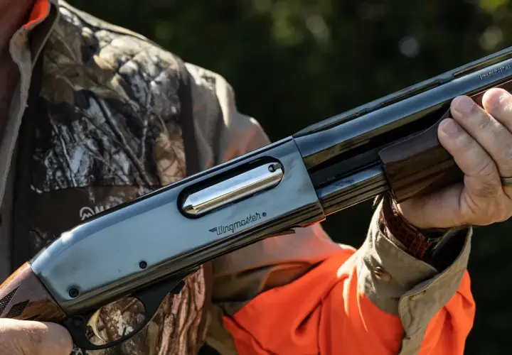 Un chasseur tient une arme Remington Wingmaster, un fusil de chasse classique, prêt pour l'action.
