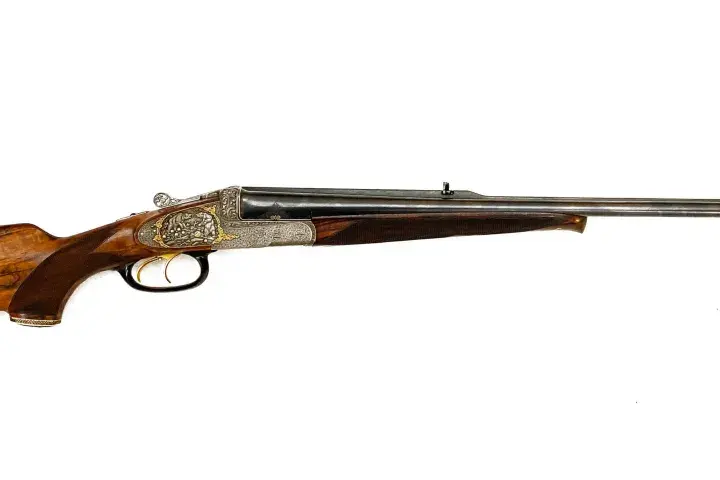 Carabine de chasse à double canon, ornée de gravures fines. Son bois veiné et sa conception suggèrent la carabine de chasse la plus puissante pour les grands gibiers.