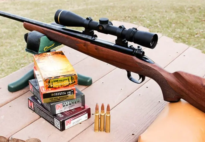 Carabine avec lunette, boîtes de munitions 338 Win Mag et cartouches, prête pour la chasse au chevreuil.