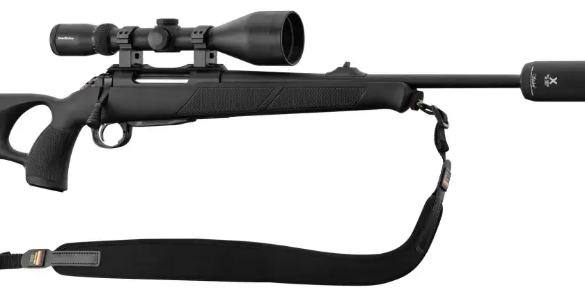 Carabine noire avec lunette et silencieux, idéale pour l'affût sanglier. Prête pour l'action.