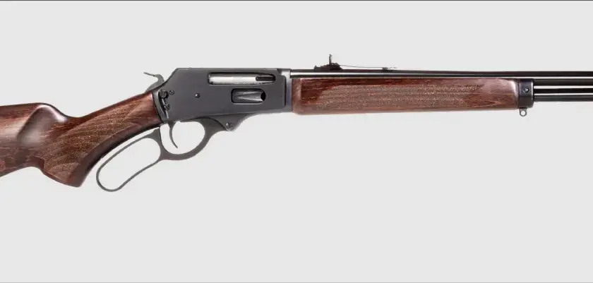 Carabine courte pour traqueur, avec crosse et garde-main en bois sombre, mécanisme à levier sous garde. Idéale pour la chasse discrète.