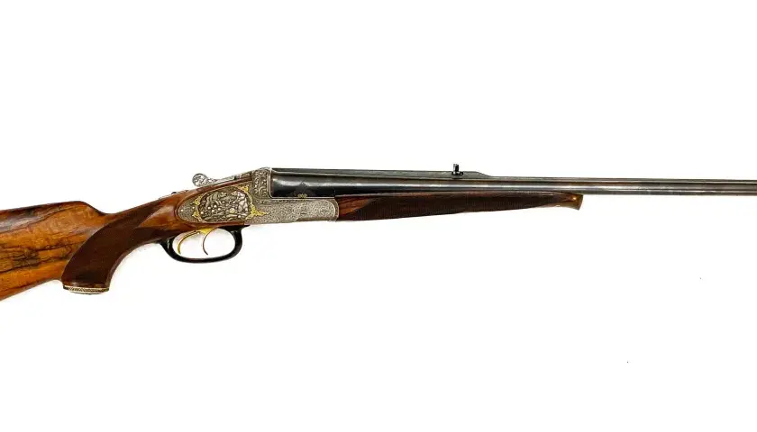 Carabine de chasse à double canon, ornée de gravures fines. Son bois veiné et sa conception suggèrent la carabine de chasse la plus puissante pour les grands gibiers.