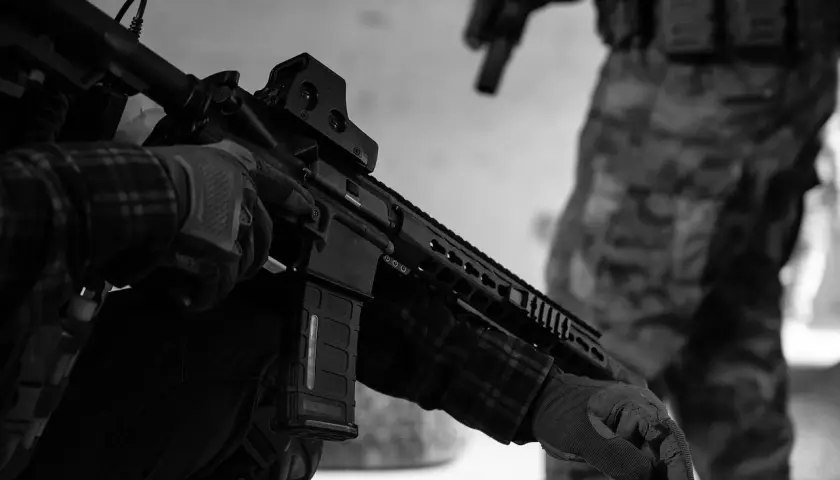 Maintenant, peut-on avoir un airsoft dans sa voiture ? Un joueur en tenue tactique manipule son réplique d'airsoft.