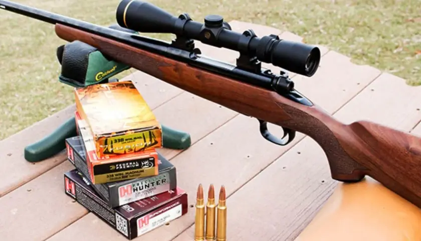Carabine avec lunette, boîtes de munitions 338 Win Mag et cartouches, prête pour la chasse au chevreuil.