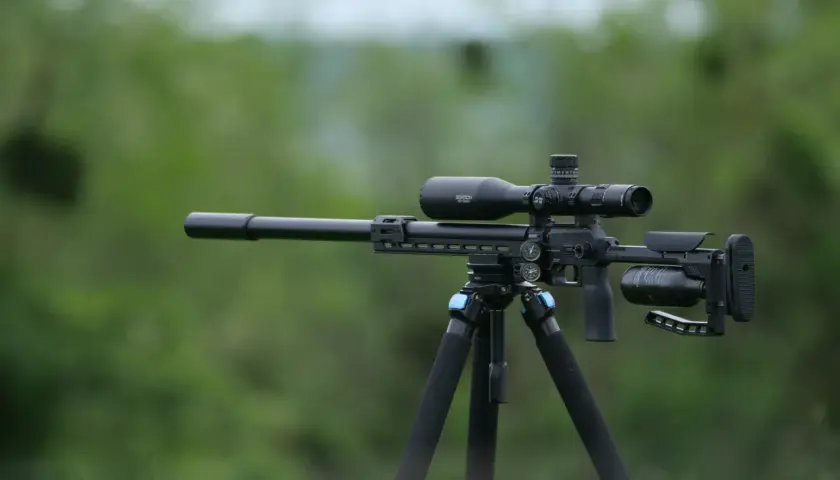 Carabine PCP sur trépied, prête pour le tir. Le choix du bon compresseur est essentiel pour la performance.