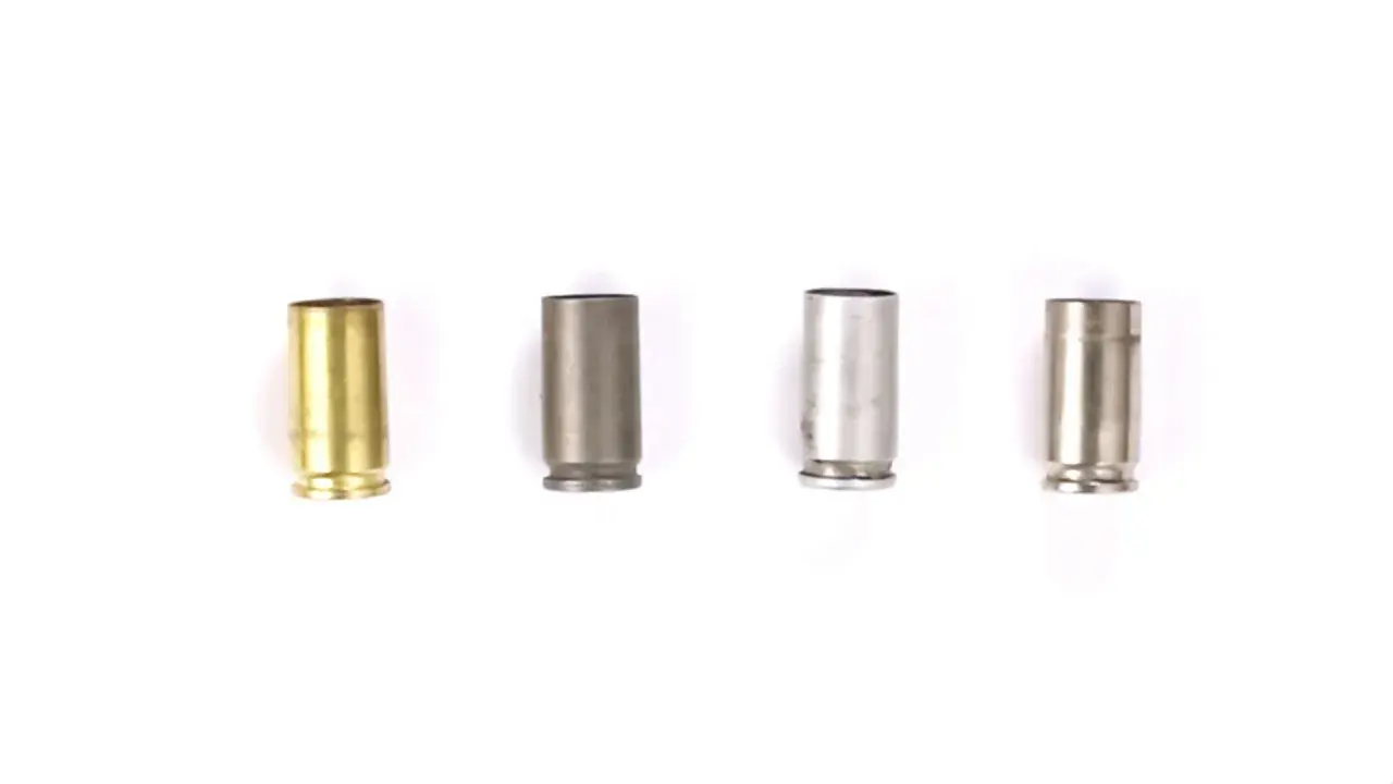 Quatre douilles de balle de différents matériaux : laiton, acier gris, acier argenté et acier brossé.