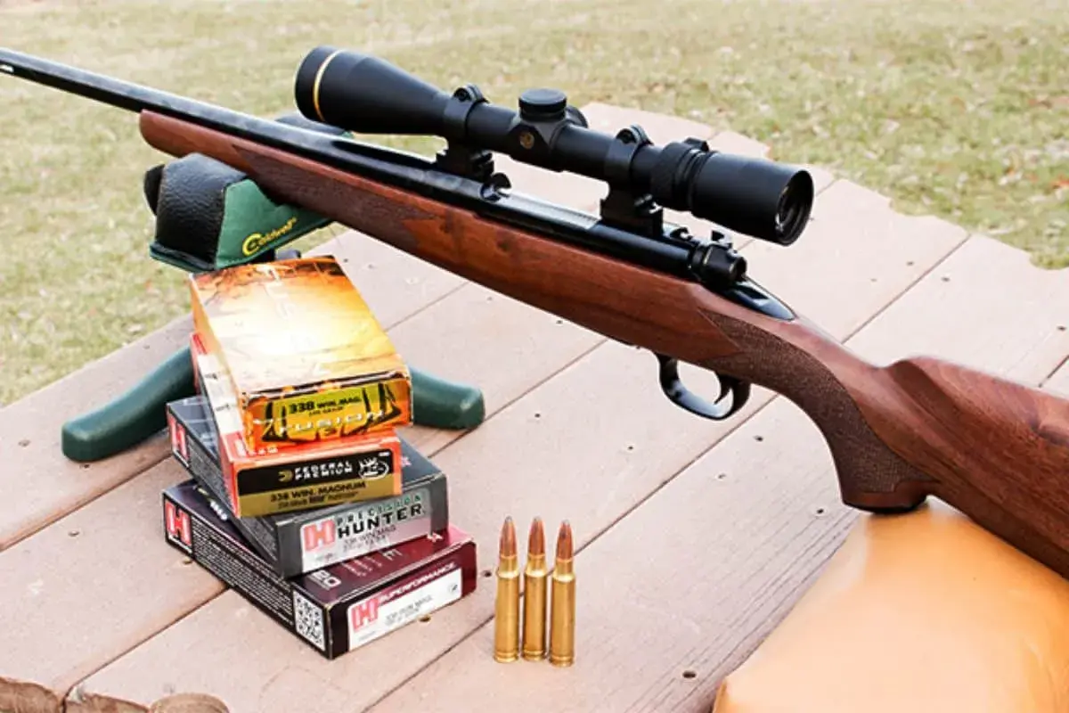 Carabine avec lunette, boîtes de munitions 338 Win Mag et cartouches, prête pour la chasse au chevreuil.