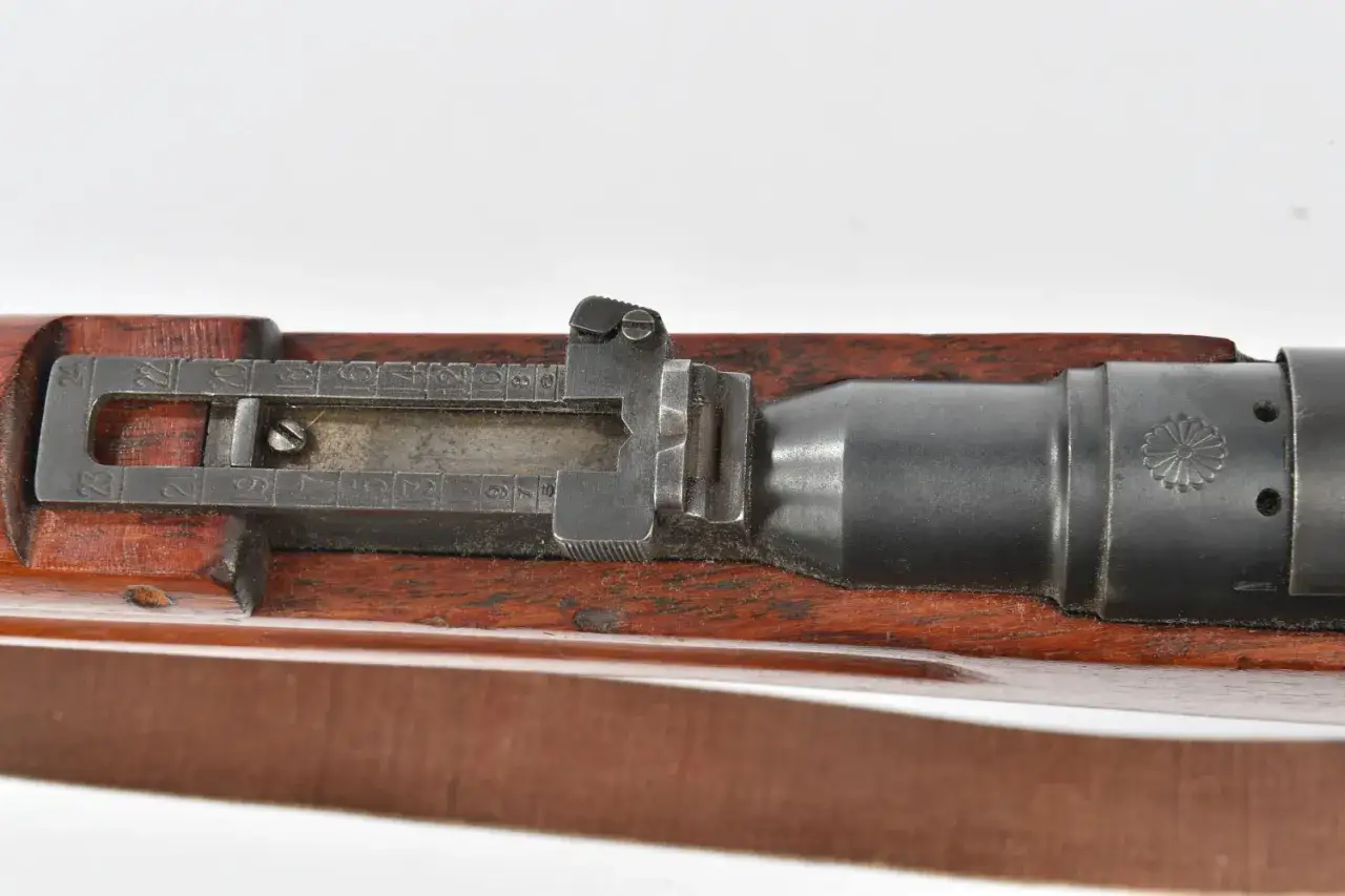 Gros plan sur la culasse d'un fusil japonais, avec sa mire r&eacute;glable et le symbole imp&eacute;rial grav&eacute;.