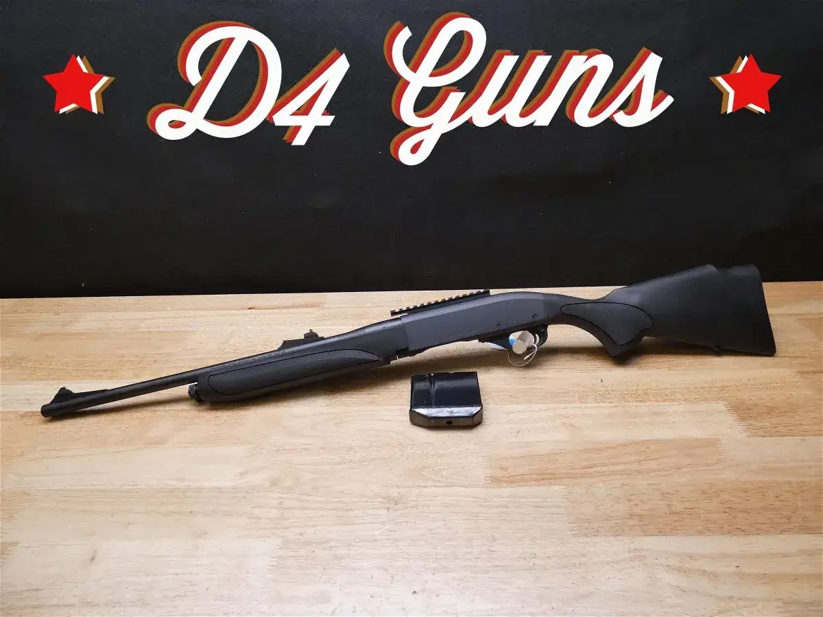 Carabine Remington 750 noire, pr&ecirc;te pour l'action. Un chargeur est pos&eacute; &agrave; c&ocirc;t&eacute;.