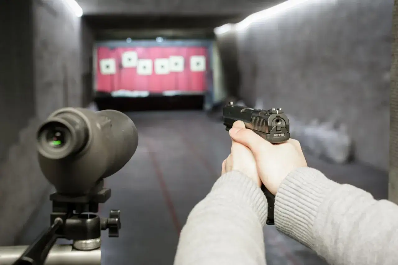 Tir à la catégorie C dans un stand de tir. Un pistolet est tenu en main, prêt à tirer sur des cibles au loin.