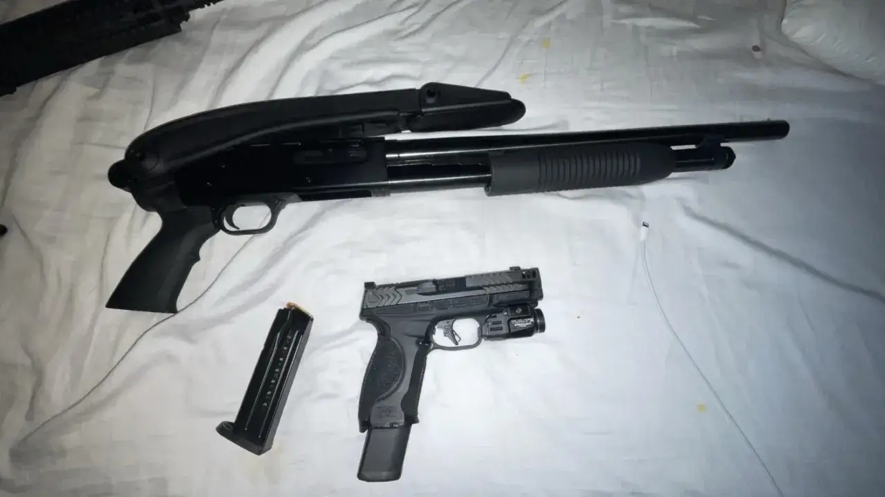 Un fusil Maverick 88 tactique, un pistolet et un chargeur sur un drap blanc.