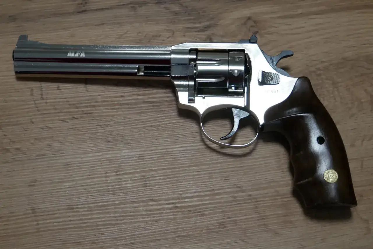 Revolver chromé avec poignée en bois, prêt à tirer des cartouches 9mm grenaille.